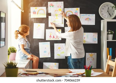 Mother and child girl hang their drawings on the wall
 - Powered by Shutterstock