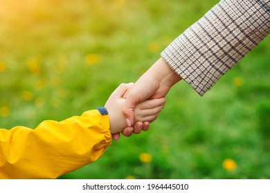 Mother And Child Hands Reaching To Each Other. Support, Help And Trust. Parent Holds The Hand Of A Child On A Walk. Kid And Mother Hands On Nature Background. Love, Relationship And Teamwork In Family