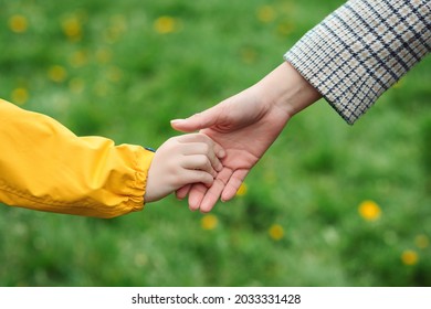 Mother And Child Hands Reaching To Each Other. Support, Help And Trust. Parent Holds The Hand Of A Child On A Walk. Kid And Mother Hands On Nature Background. Love, Relationship And Teamwork In Family