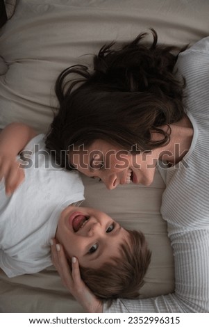 Similar – Relaxed mother and sons playing over the bed