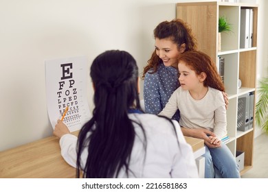 Mother And Child Have Appointment At Modern Ophthalmologist's Office. Mom And Little Kid See Doctor For Contact Lenses Or Eyeglasses Prescription. Health Professional Using Eye Chart For Eyesight Exam