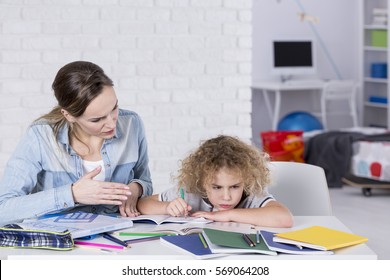 Mother And Child Having Problem With Concentration While Doing Homework