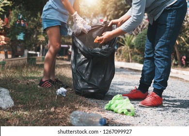 Mother and child help picking up trash at park