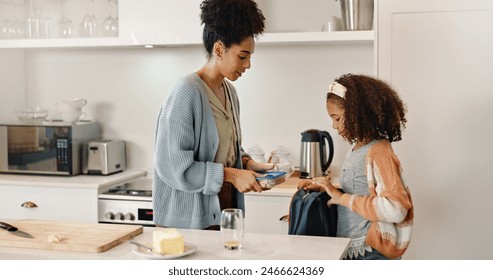 Mother, child and lunchbox with backpack packing in home kitchen or nutrition, meal or morning. Woman, daughter and young student for learning development or school food for wellness, health or snack - Powered by Shutterstock