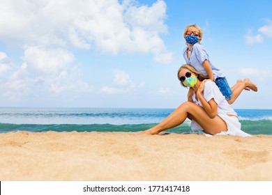 Mother, child in masks have fun on sea beach. New rules to wear cloth face covering at public places. Cancelled cruise, tour due coronavirus COVID 19. Family vacation, travel lifestyle at summer 2020
