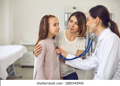 Mother and child at medical checkup at hospital or clinic. Friendly female doctor listening to young patient's breath or heartbeat. Smiling pediatrician with stethoscope checking little girl's lungs