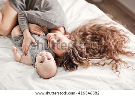 Similar – Relaxed mother and sons playing over the bed