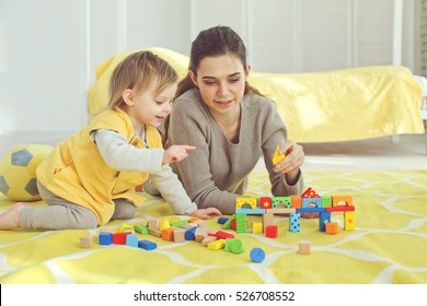 Mother With Child Playing Educational Toys In The Room