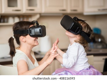 Mother and child playing together with virtual reality headsets indoors at home - Powered by Shutterstock