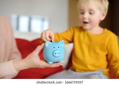 Mother And Child Putting Coin Into Piggy Bank. Education Of Children In Financial Literacy. Money, Cash, Investment.