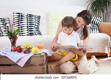 Mother And Child, Reading A Book And Eating Fruits