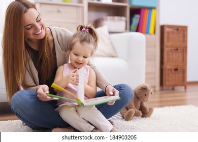 Mother And Child Reading Book At Home 