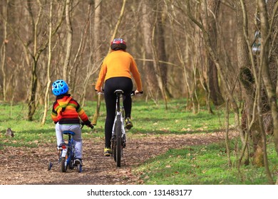 Mother and child riding bikes together during springtime