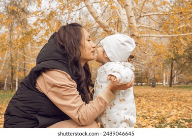 Mother and Child Sharing Joyful Moment in Autumn Park: Family Bonding Amidst Golden Foliage - Powered by Shutterstock