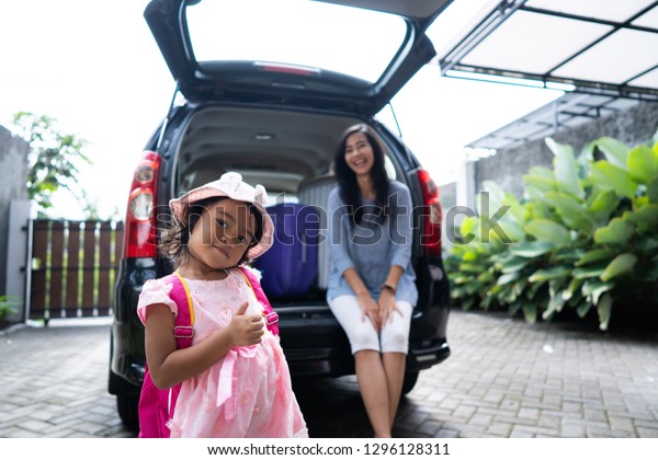 mother and child sitting in the car\
trunk. preparing for summer holiday in the beach with\
family