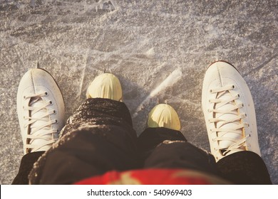 Mother And Child Skating Together In Winter