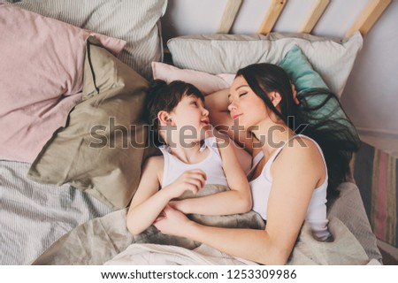 mother and child son sleeping together in bed