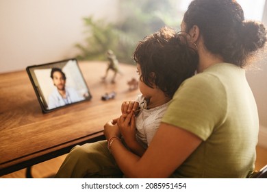 Mother and child video calling their family doctor on a digital tablet. Mother and son having an online consultation with their paediatrician. Loving young mother caring for her sick son at home. - Powered by Shutterstock