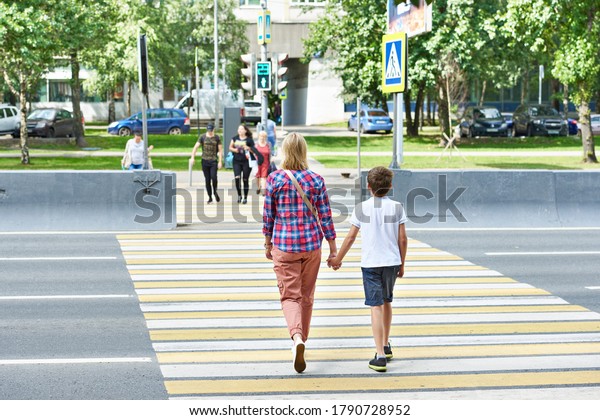 Mother and child\
walk on pedestrian\
crossing