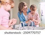 Mother, child and washing hands in bathroom for cleaning, help and learning. Mom, young girl and hygiene at home with soap, foam bubbles and support in family with care and development for growth