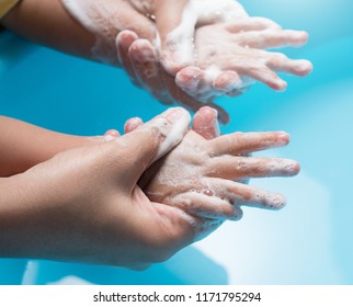 Mother And Child Washing Hands With Soap And Water