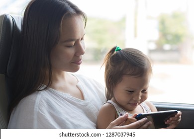 A Mother And Child Watching Tv On The Train, Traveling Together. 