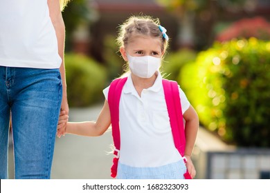 Mother And Child Wearing Face Mask Going To School During Coronavirus Or Flu Outbreak. Surgical Mask For Illness Prevention. Mom And Kid At Kindergarten Or Preschool During Covid 19 Pandemic.