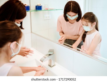 Mother And Child Wearing Face Masks And Washing  Hands During Coronavirus  Outbreak