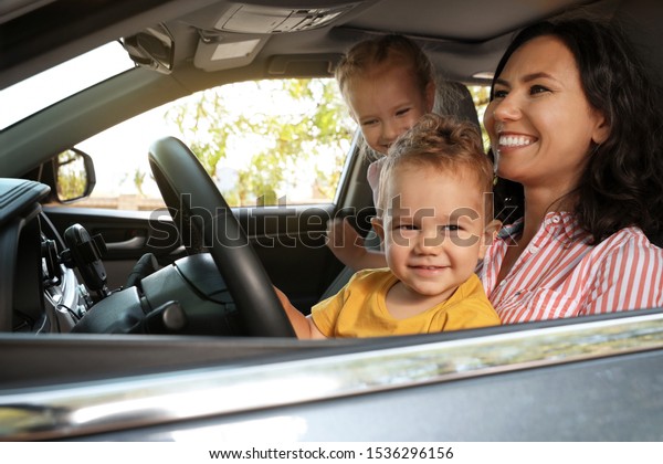 Mother and children in\
car. Family trip