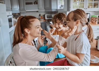 Mother and children having fun with chocolate in the kitchen - Powered by Shutterstock