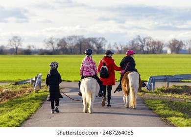 Madre con los niños que se divierten paseando a caballo en poni a caballo en el bosque de campo agrícola en otoño día soleado. Persona con niños y animales aventura paisaje rural paisajístico