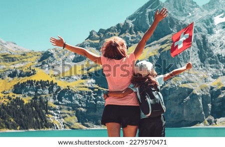 Mother and children holding swiss flag- Alps mountain and lake