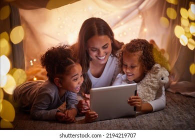 Mother And Children Live Streaming Movies On Tablet Or Digital Kids App In A Tent Camping At Night And Bokeh Lights. Care, Love Mom Reading Ebook To Happy Girl Or Online Games With Home Wifi In Dark