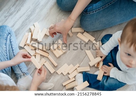 mother with children plays a game of django on the floor. High quality photo
