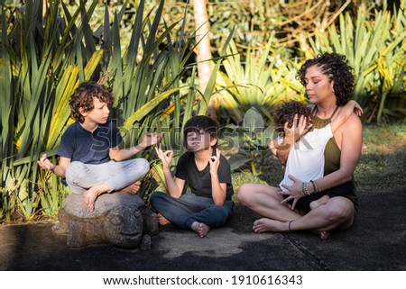 Mother and children practicing yoga outdoors on a beautiful afternoon