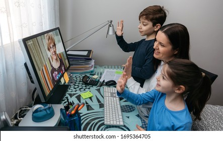 Mother And Children Waving On Video Call With Computer With Grandmother