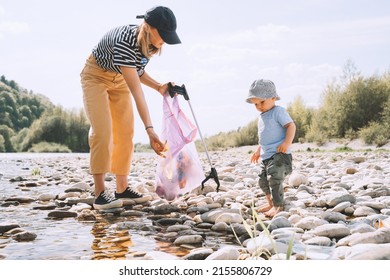 Mother clean up outdoor area from rubbish near her playing toddler son. Volunteers family collecting plastic waste trash on water of river. People help to keep nature clean up and pick up garbage. - Powered by Shutterstock