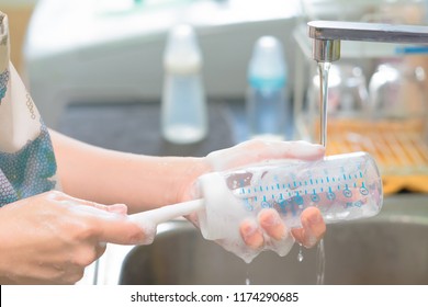 Mother Cleaning Baby Milk Bottles With Bottle Brush. Selective Focus. Copy Space.