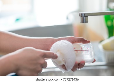 Mother Cleaning Baby Milk Bottles With Bottle Brush.