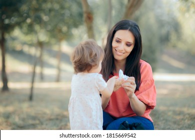 Mother Cleaning Her Daughter Hands With Antibacterial Wipes. Overprotective Mom Cleaning Toddlers Hands After Playing 
