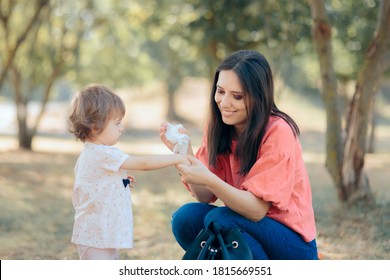 Mother Cleaning Her Daughter Hands with Antibacterial Wipes. Overprotective mom cleaning toddlers hands after playing 
