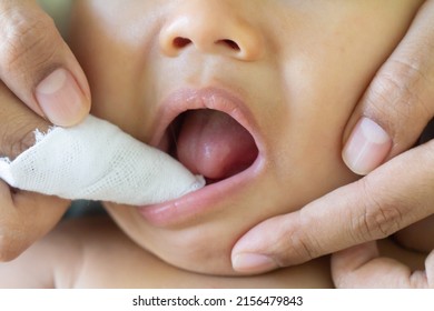 Mother Cleans The Teeth Of A Little Boy, Him To Reduce Pain From Erupting , Baby Teethfingertip Brush For Children,  Clean Cloth Fter Bathing At Home, Asian Family, Hygiene. Zoom Selective Focus