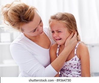 Mother comforting her crying little girl - parenthood concept
