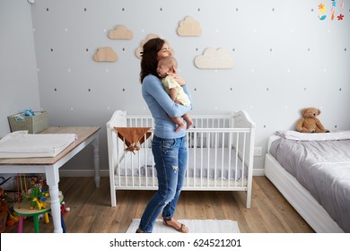 Mother Comforting Newborn Baby Son In Nursery - Powered by Shutterstock