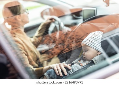 Mother Concentrating On Driving Family Car Running Errands While Her Baby Sleeps In Infant Car Seat By Her Site.