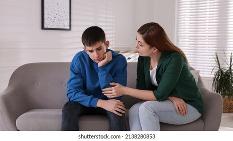 Mother consoling her depressed son at home. Teenager problems - Powered by Shutterstock