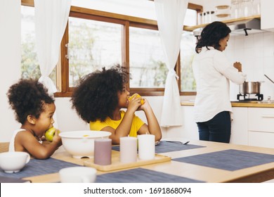 Mother Cooking For Her Two Children Waiting For Lunch. Single Mom Concept.