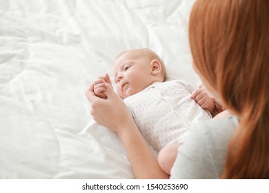 Mother With Cute Baby Lying On Bed