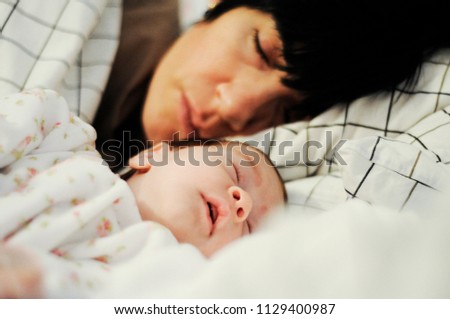 Mother and cute little baby girl sleeping