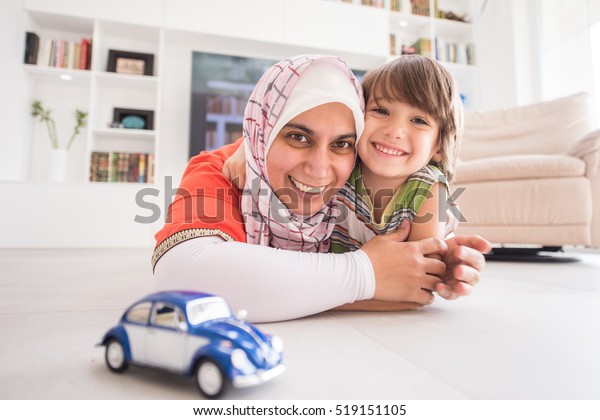 Mother
and cute son playing with car toy at living
room